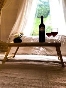 una mesa de madera con dos copas de vino. en Cottage Rest in kazbegi en Stepantsminda