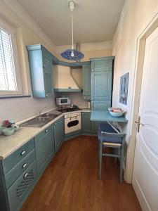 a kitchen with blue cabinets and a sink and a table at La Chiave di Sol 2 in Lucca +26 photos