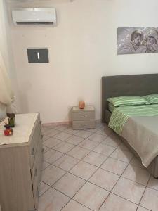1 dormitorio con 1 cama y suelo de baldosa en Casetta in villa indipendente en Angri