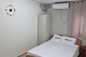 a bedroom with a bed with a clock on the wall at הבית בפיקא. צמוד לרמבם in Tiberias