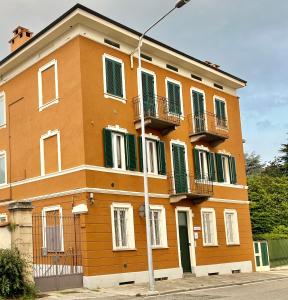 a orange building with green windows and a street light at Alloggio Nina 2 in Biella