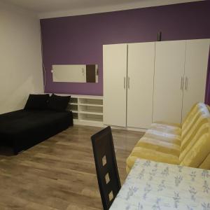 a living room with a black couch and a table at SAWAGO Płocka Mieszkanie Parter - Samodzielne zameldowanie in Ciechanów