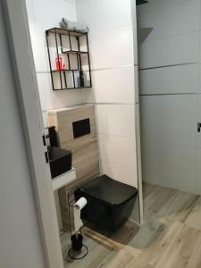 a bathroom with a black toilet and a mirror at Domek na roztoczu in Tomaszów Lubelski