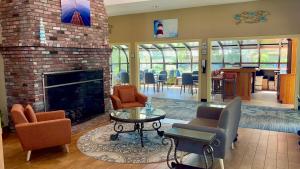 a living room with a fireplace and a table and chairs at All Seasons Resort, Trademark Collection by Wyndham in South Yarmouth