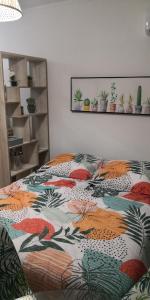 ein Bett mit farbenfroher Bettdecke in einem Schlafzimmer in der Unterkunft Studio équipé Clim TV Wifi in Saint-Denis