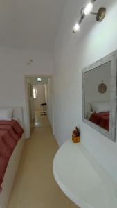 Habitación blanca con cama y espejo en la pared en suite diminutif 2, en Adamas