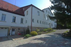 un gran edificio blanco con techo rojo en Hotel U Zeleného Stromu - Zum Grünen Baum, en Hřensko