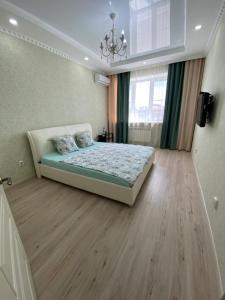 a bedroom with a bed and a chandelier at 1 комнатная квартира ЖК Альтаир в центре города in Aktobe