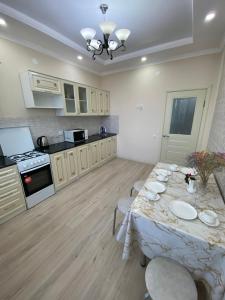 a kitchen with a table with chairs and a stove at 1 комнатная квартира ЖК Альтаир в центре города in Aktobe +14 photos