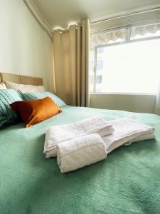 a bed with two towels on it with a window at Charme Copa Retreat próximo ao Copacabana Palace in Rio de Janeiro