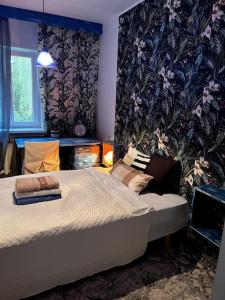 ein Schlafzimmer mit einem Bett und einer Wand mit Blumen in der Unterkunft Cosy house with forest view in Pyussi