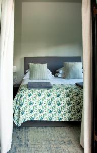 1 dormitorio con 1 cama grande con manta y almohadas en Newstead Farm, en Curryʼs Post