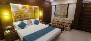 a bedroom with a bed and a bench in it at Hotel Jigyasa By Mayda Hospitality Pvt. Ltd. in Agra