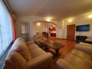 a living room with a couch and chairs and a table at Apartments Renato in Zadar