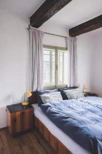 sypialnia z łóżkiem z niebieską pościelą i oknem w obiekcie Chaloupka Na Gruni w mieście Hrádek