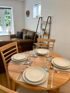 a wooden table with plates and wine glasses on it at 14 Granite Henge in Looe