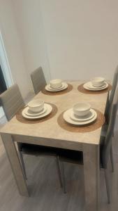 une table avec quatre chaises et des assiettes dans l'établissement Aqua Suite, à Gillingham