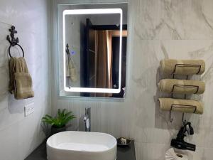 a bathroom with a white toilet and a mirror at Urban Hotel Ancla Suite 10 - 3 Bedroom 2 Bathroom in Puerto Peñasco