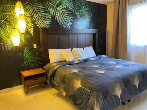 Urban Hotel Ancla Suite 10 - 3 Bedroom 2 Bathroom في بورتو بيناسكو: غرفة نوم مع سرير مع جدار نباتي كبير