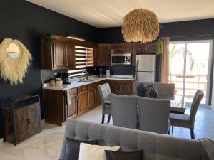 a kitchen with wooden cabinets and a table with chairs at Urban Hotel Ancla Suite 10 - 3 Bedroom 2 Bathroom in Puerto Peñasco