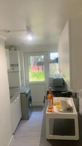 a kitchen with white cabinets and a table in it at Aqua Suite in Gillingham