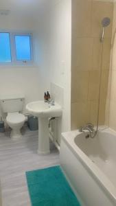 La salle de bains est pourvue d'un lavabo, de toilettes et d'une baignoire. dans l'établissement Aqua Suite, à Gillingham