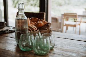 a table with four wine glasses and a basket of bread at B&B Martinushoeve in Oudenaarde