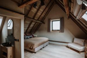 a bedroom with a bed and a couch and a window at B@B Martinushoeve in Oudenaarde