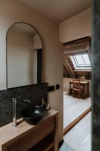 La salle de bains est pourvue d'un lavabo et d'un miroir. dans l'établissement B@B Martinushoeve, à Audenarde