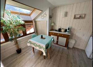 a small room with a table and a kitchen at Le Cosy Liberty in Ustou