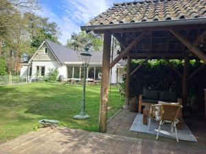 - un pavillon avec une table, des chaises et une lampe dans l'établissement Boomhut, à Rijsbergen