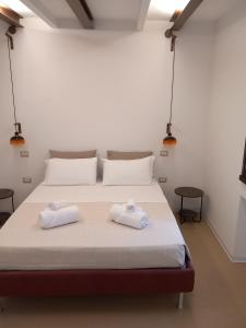 1 dormitorio con 1 cama con 2 toallas en La casetta Guest House Oristano, en Oristano