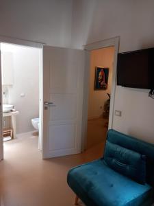 a living room with a couch and a television at La casetta Guest House Oristano in Oristano