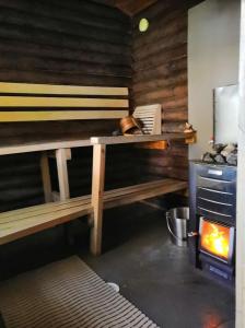 uma cozinha com um banco de madeira e um fogão em Lysti Cottage by the lake and magical countryside em Rovaniemi