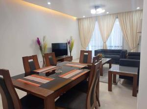a living room with a table and chairs and a couch at Lovely Apt 2bd 2ba+DSQ - walking dist to UN-ECA, Addis Ababa in Addis Ababa
