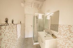 bagno bianco con lavandino e specchio di B&B Lambroriver a Merone