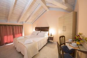 a bedroom with a large white bed and a table at B&B Lambroriver in Merone +14 photos
