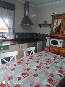uma cozinha com uma mesa com uma toalha de mesa em La Buganvilla em Ribadesella