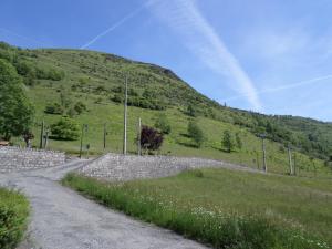 una pared de piedra junto a una carretera con una montaña en L'Esquerade, en Castillon-de-Larboust