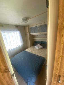 niewielka sypialnia z łóżkiem i oknem w obiekcie Dulczetto Camp w Jastarni