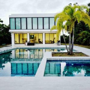 ein Haus mit einem Pool vor einem Gebäude in der Unterkunft Ultimate Beach Getaway, Luxury villa in Ritz-Carlton, Dorado 5 mins to Beach in Dorado