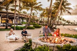 un grupo de personas sentadas alrededor de una hoguera en un resort en Ultimate Beach Getaway, Luxury villa in Ritz-Carlton, Dorado 5 mins to Beach, en Dorado