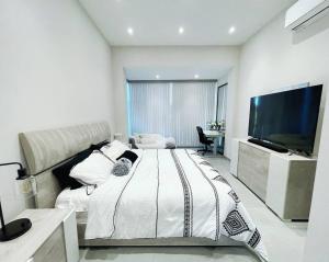 Ultimate Beach Getaway, Luxury villa in Ritz-Carlton, Dorado 5 mins to Beach في دورادو: غرفة نوم بسرير كبير وتلفزيون بشاشة مسطحة