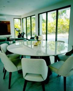 a dining room with a white table and chairs at Ultimate Beach Getaway, Luxury villa in Ritz-Carlton, Dorado 5 mins to Beach in Dorado