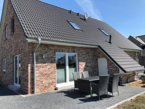 a brick house with a table and chairs at Ferienhof-Micheel in Gammendorf