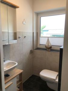 een badkamer met een toilet, een wastafel en een raam bij Ferienhof-Micheel in Gammendorf