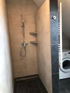 a bathroom with a shower with a washing machine at Ferienhof-Micheel in Gammendorf