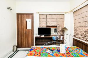 a bedroom with a bed and a television in a room at Hotel Ullash Residency Salt Lake Kolkata - fully-air-conditioned-hotel spacious-room with-parking-facility in Salt Lake City