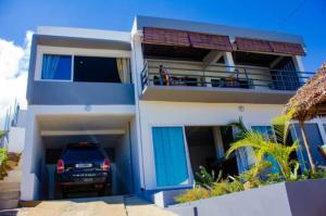een huis met een auto ervoor geparkeerd bij Résidence Riziq villa 2 in Nosy Be