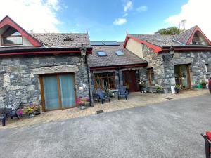 a stone house with a patio in front of it at Salmon Weir Lodge in Cong